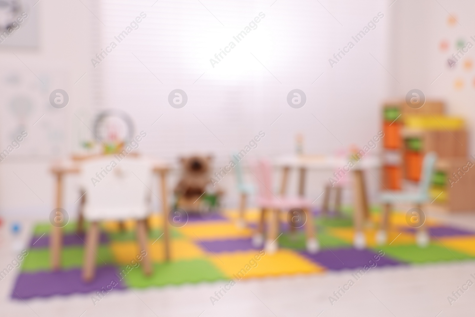 Photo of Stylish kindergarten interior with toys and modern furniture, blurred view