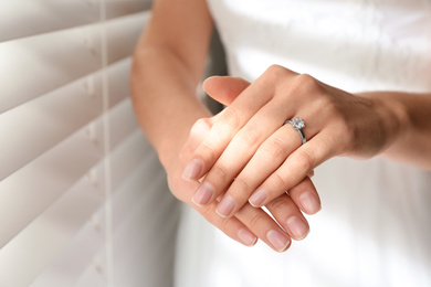 Photo of Young bride wearing beautiful engagement ring, closeup