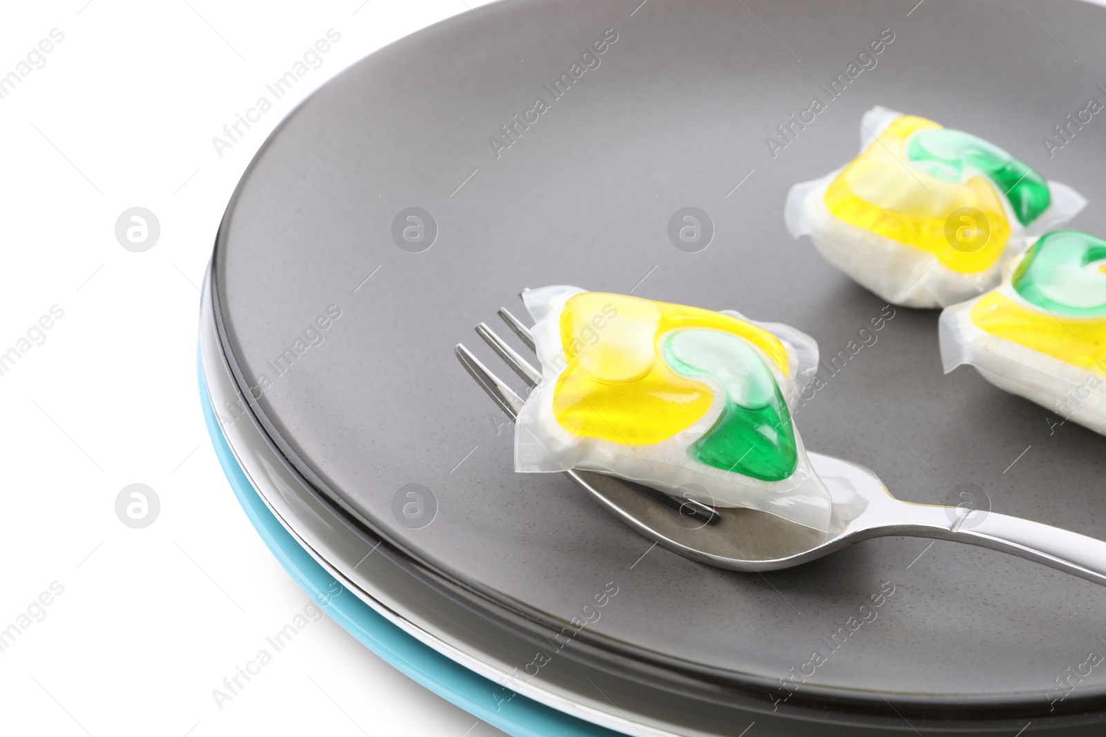 Photo of Dishware with dishwasher detergent pods on white background