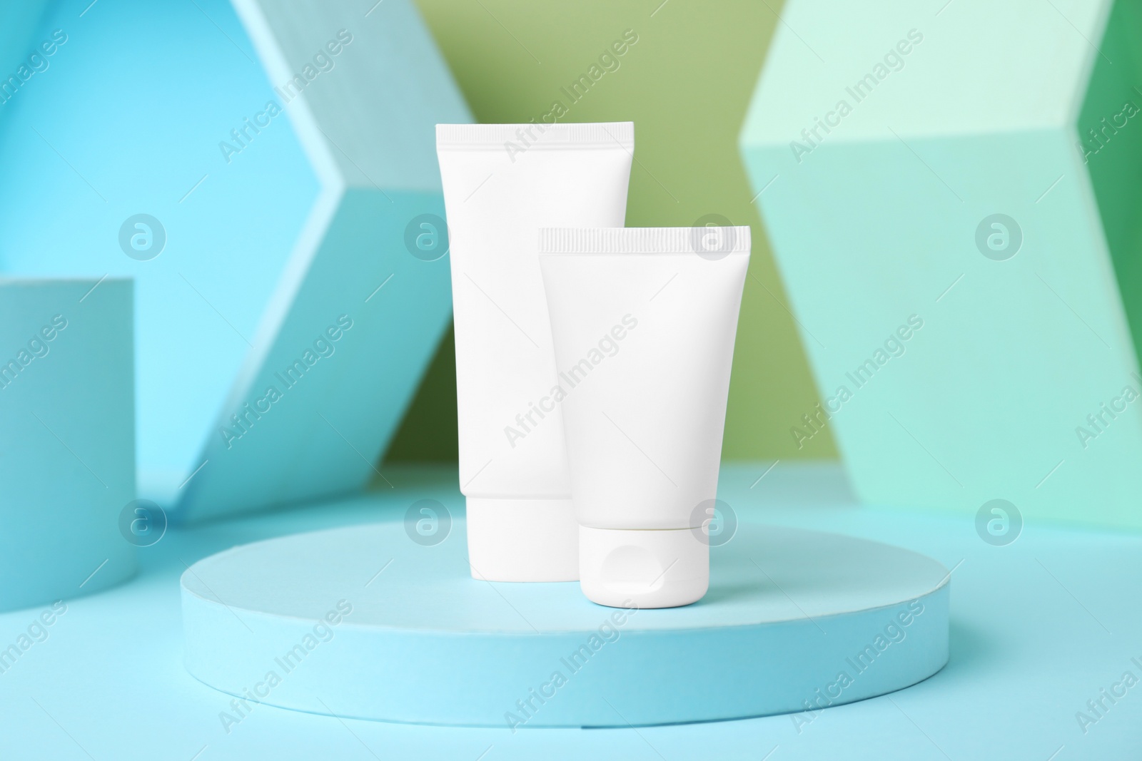 Photo of Composition with tubes of hand cream on light blue table