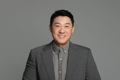 Portrait of happy businessman on grey background