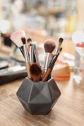 Photo of Holder with makeup brushes on table