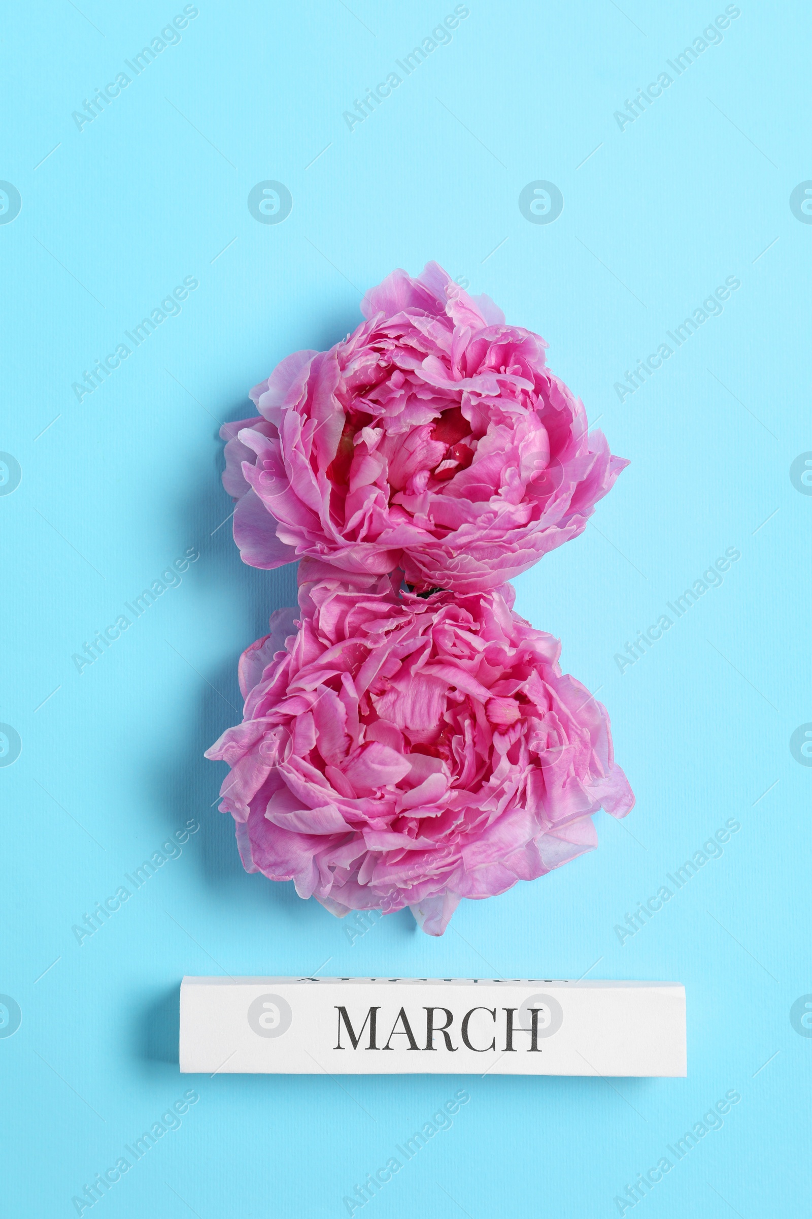 Photo of International Women's day. 8th of March made with beautiful peonies on light blue background, top view