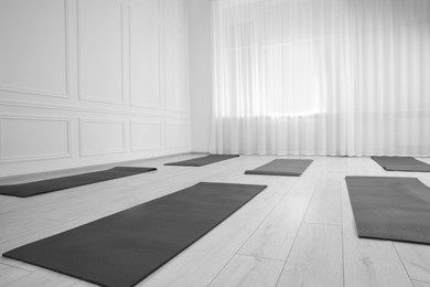 Photo of Spacious yoga studio with exercise mats. Space for text