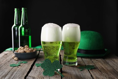 Photo of St. Patrick's day party. Green beer, decorative clover leaves, leprechaun hat and nuts on wooden table