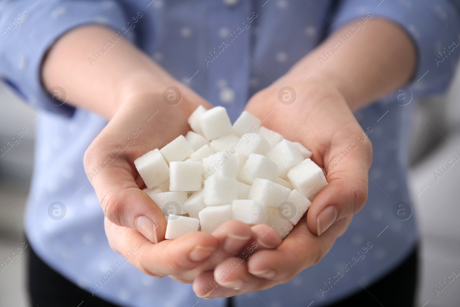 Photo of Woman holding sugar cubes, closeup