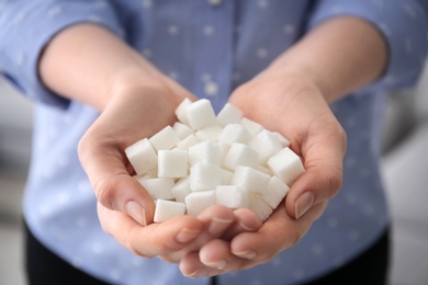 Photo of Woman holding sugar cubes, closeup