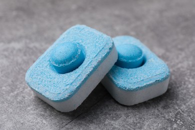 Photo of Water softener tablets on grey table, closeup