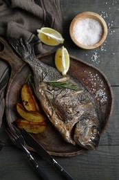 Delicious baked fish served on wooden rustic table, flat lay. Seafood