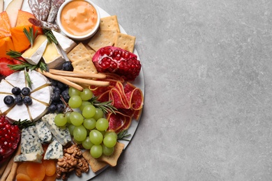 Photo of Assorted appetizers served on light grey table, top view. Space for text