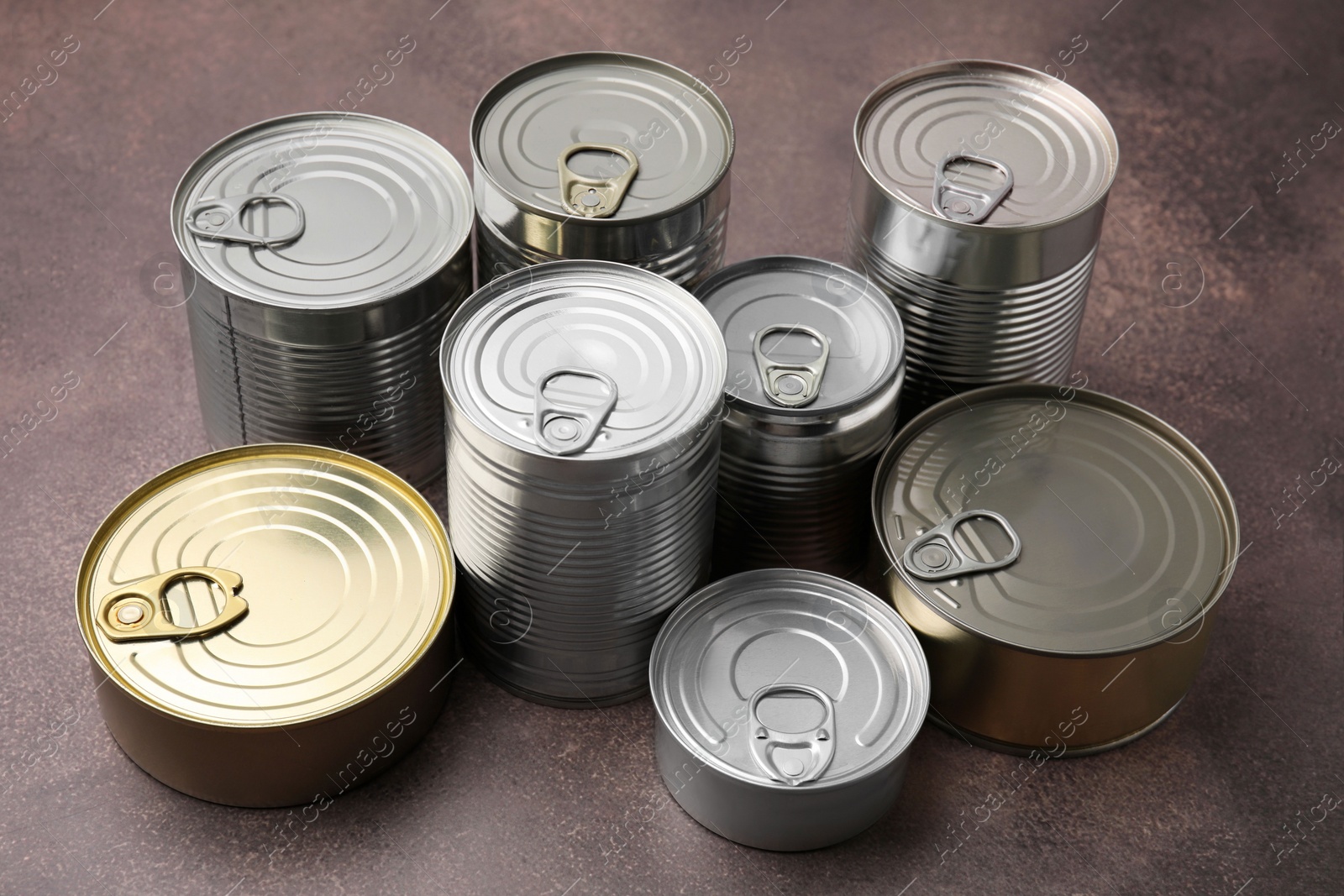 Photo of Many closed tin cans on brown table