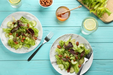 Delicious fresh celery salads served on light blue wooden table, flat lay