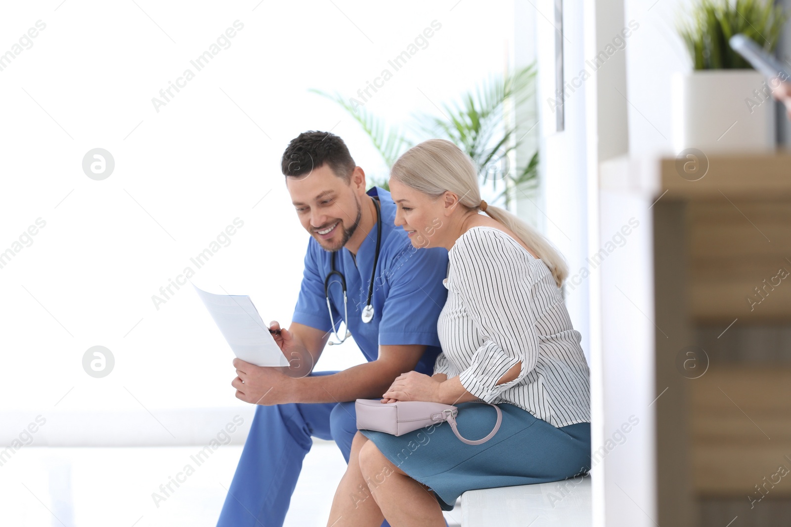 Photo of Doctor talking with patient in hospital hall