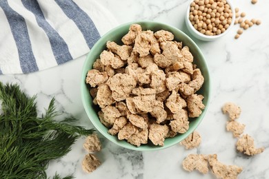 Flat lay composition with dried soy meat and beans on white marble table