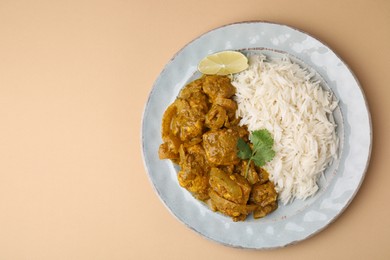 Photo of Delicious chicken curry with rice on beige background, top view. Space for text