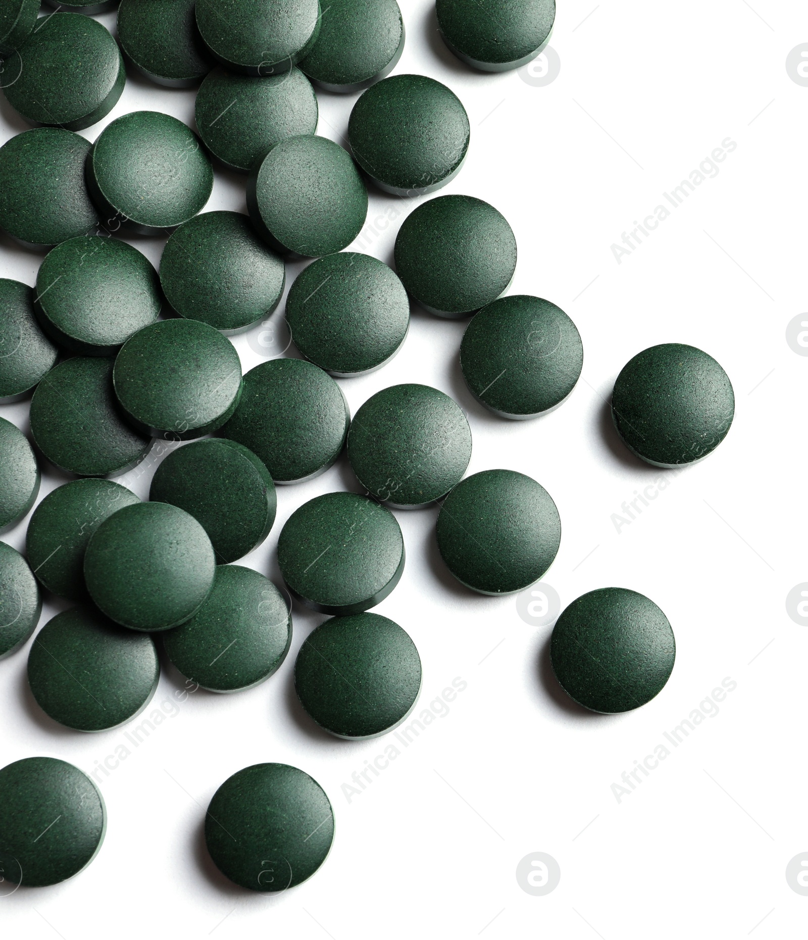 Photo of Spirulina tablets on white background, top view