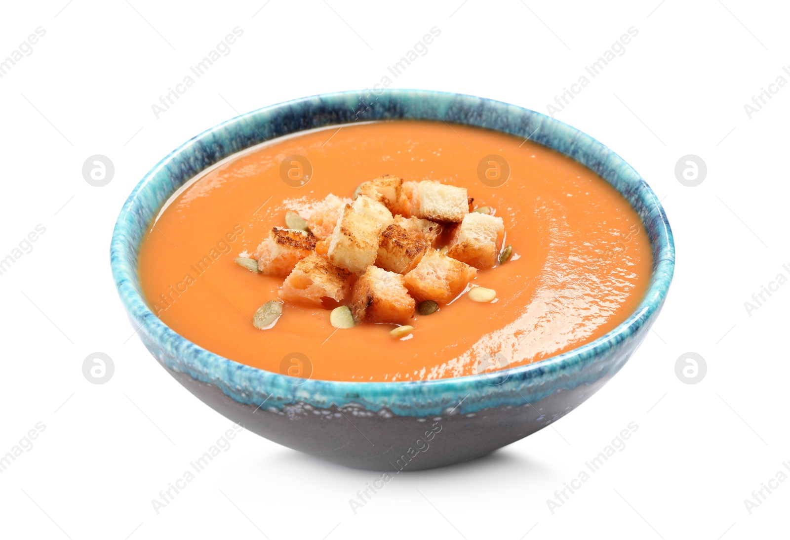 Photo of Tasty creamy pumpkin soup with croutons and seeds in bowl on white background