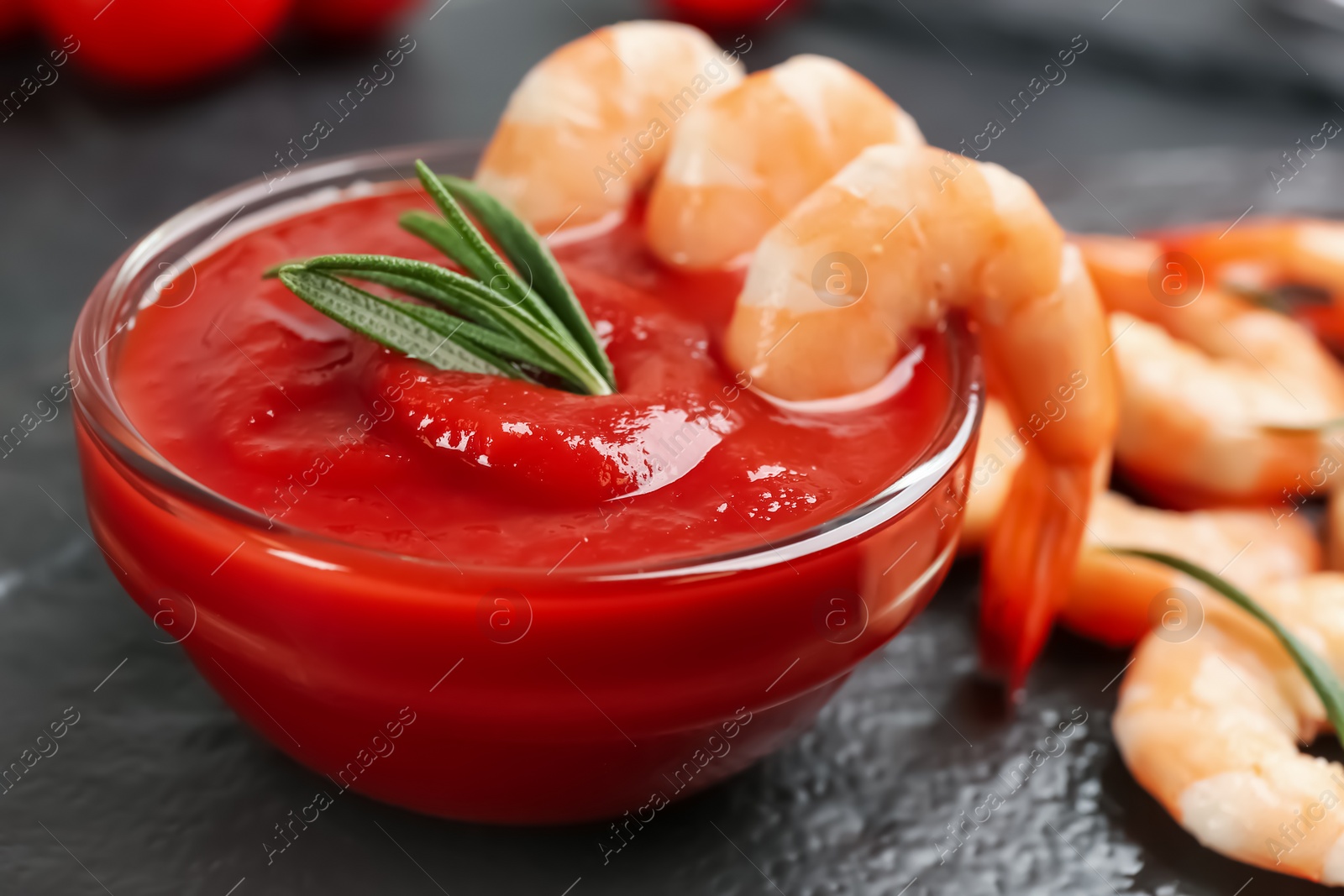 Photo of Delicious shrimp cocktail with tomato sauce served on black table, closeup