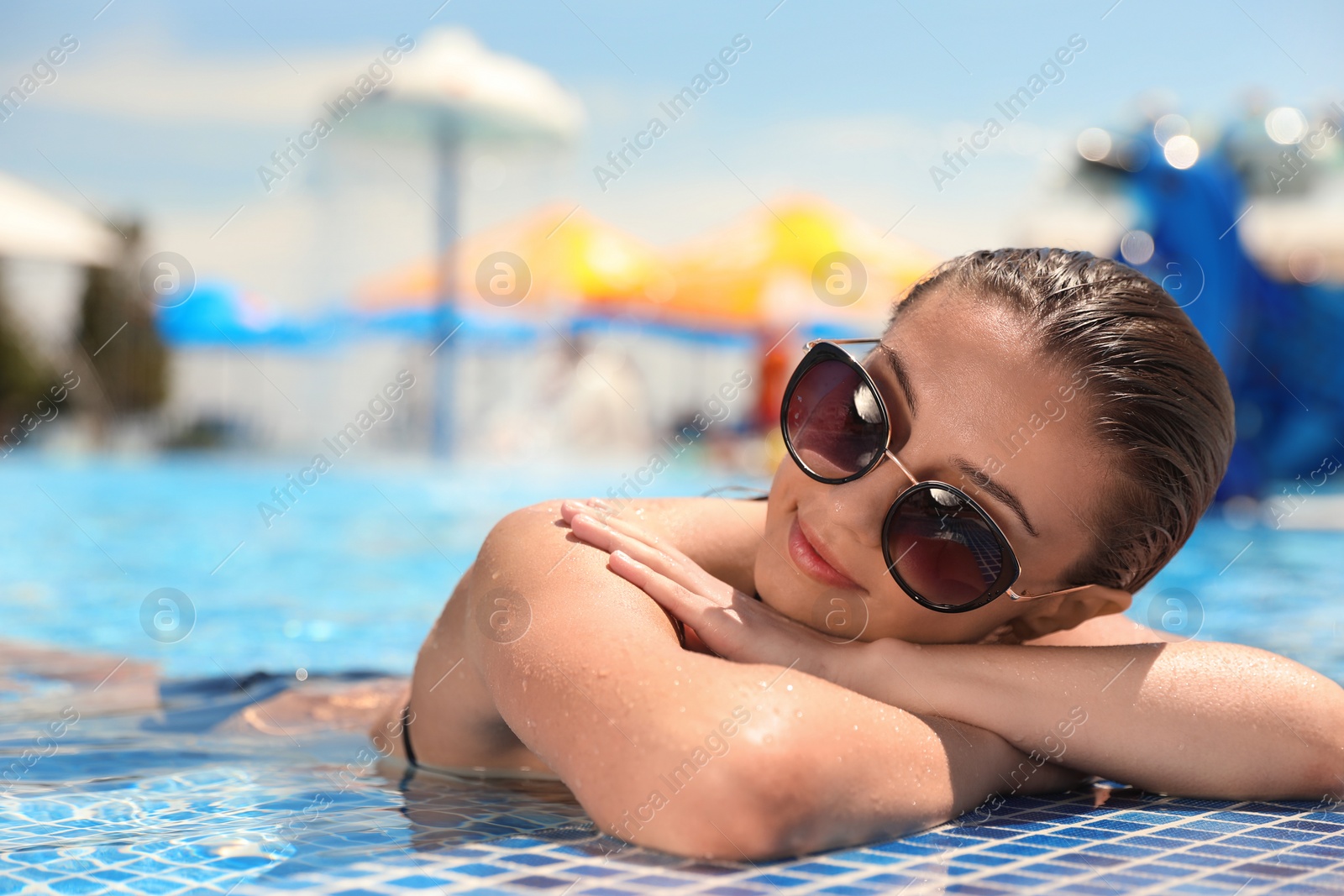 Photo of Young woman in outdoor swimming pool. Summer vacation