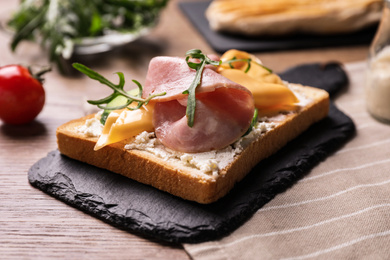 Photo of Delicious sandwich with ham on wooden table, closeup