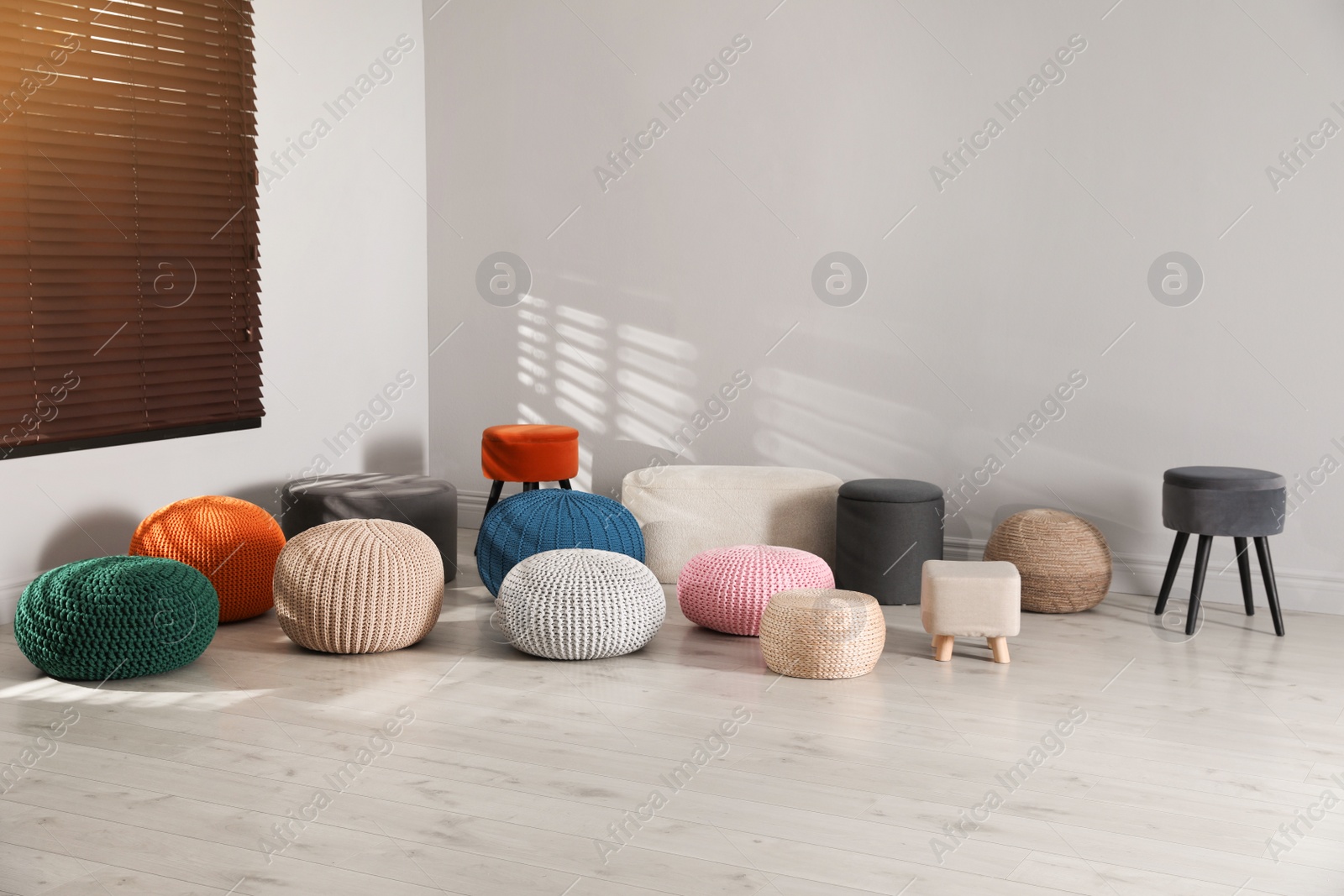 Photo of Many stylish different poufs in room. Home design