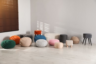 Many stylish different poufs in room. Home design