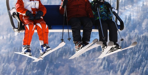 Photo of People using chairlift at mountain ski resort, closeup. Winter vacation