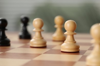 Wooden pawns on chess board, closeup. Space for text