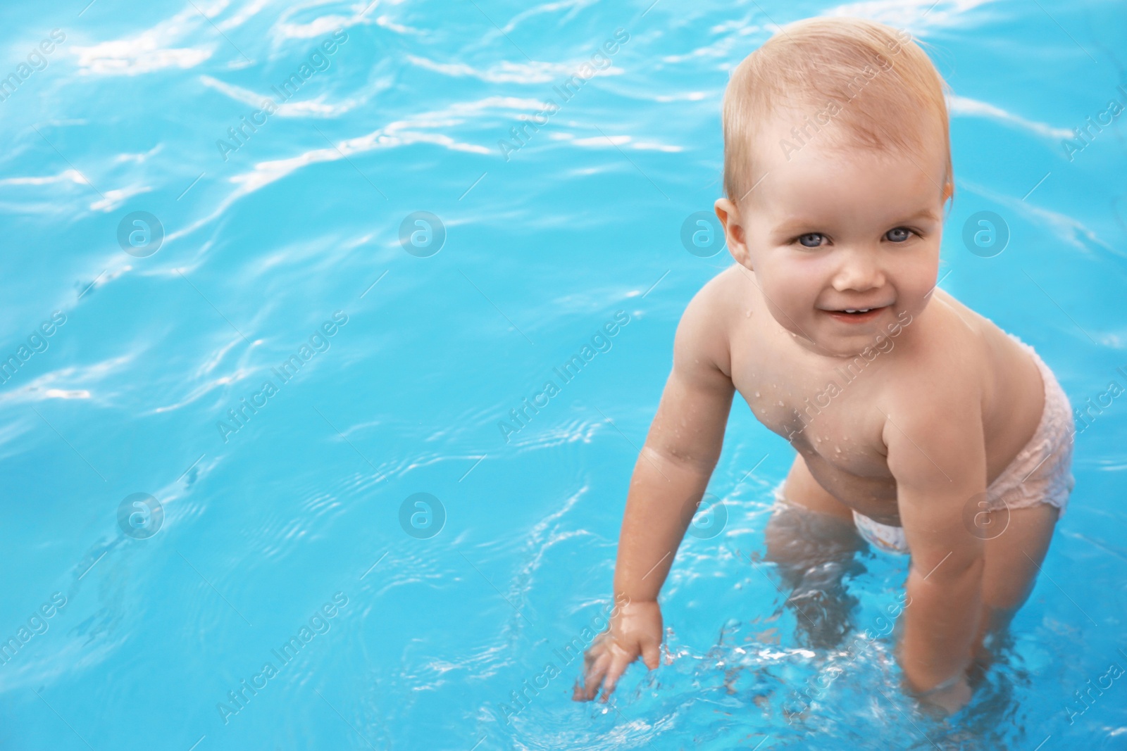 Photo of Little baby playing in outdoor swimming pool. Dangerous situation