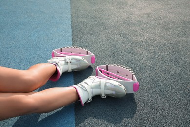 Woman with kangoo jumping boots on color textured background, closeup. Space for text