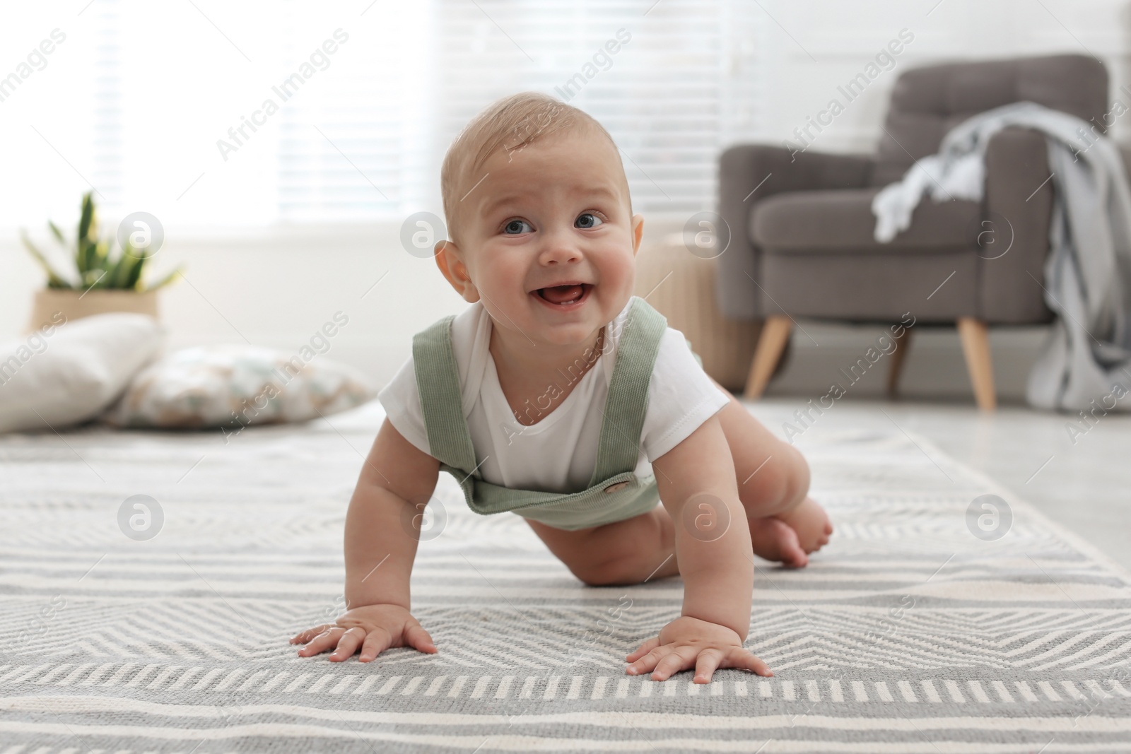 Photo of Cute baby crawling on floor at home