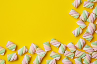 Photo of Delicious colorful marshmallows on yellow background, flat lay. Space for text