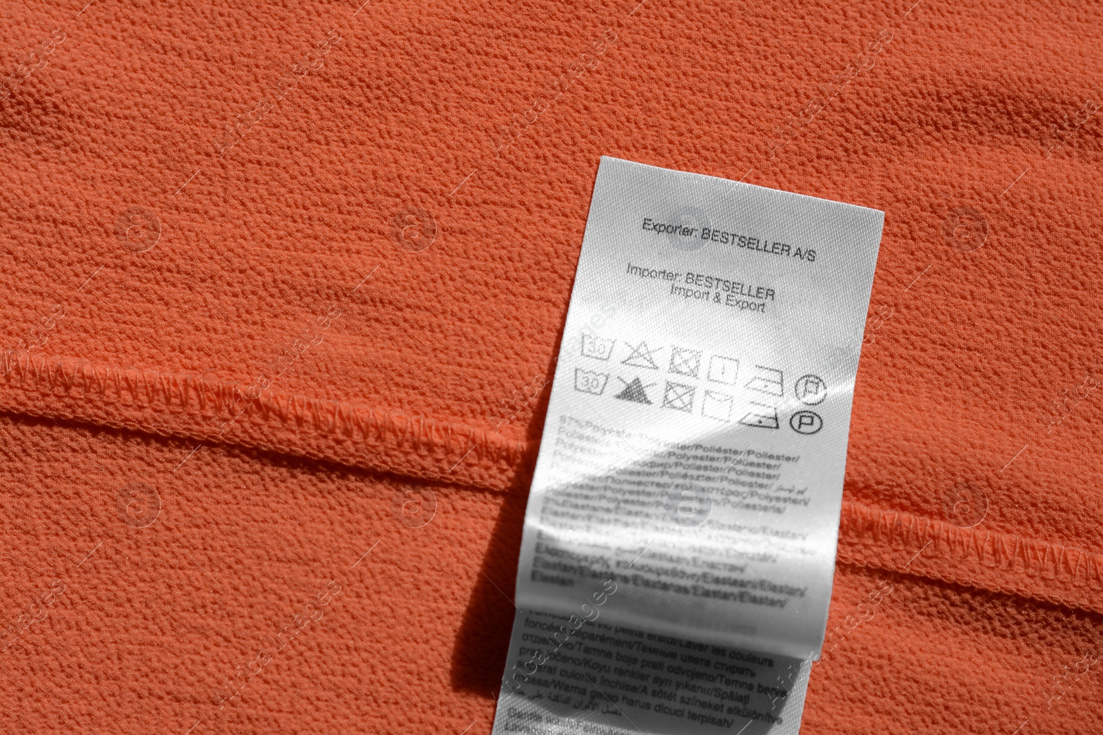 Photo of Clothing label on coral garment, top view