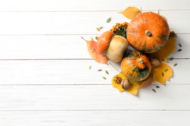 Photo of Different pumpkins on wooden background, flat lay composition with space for text. Autumn holidays