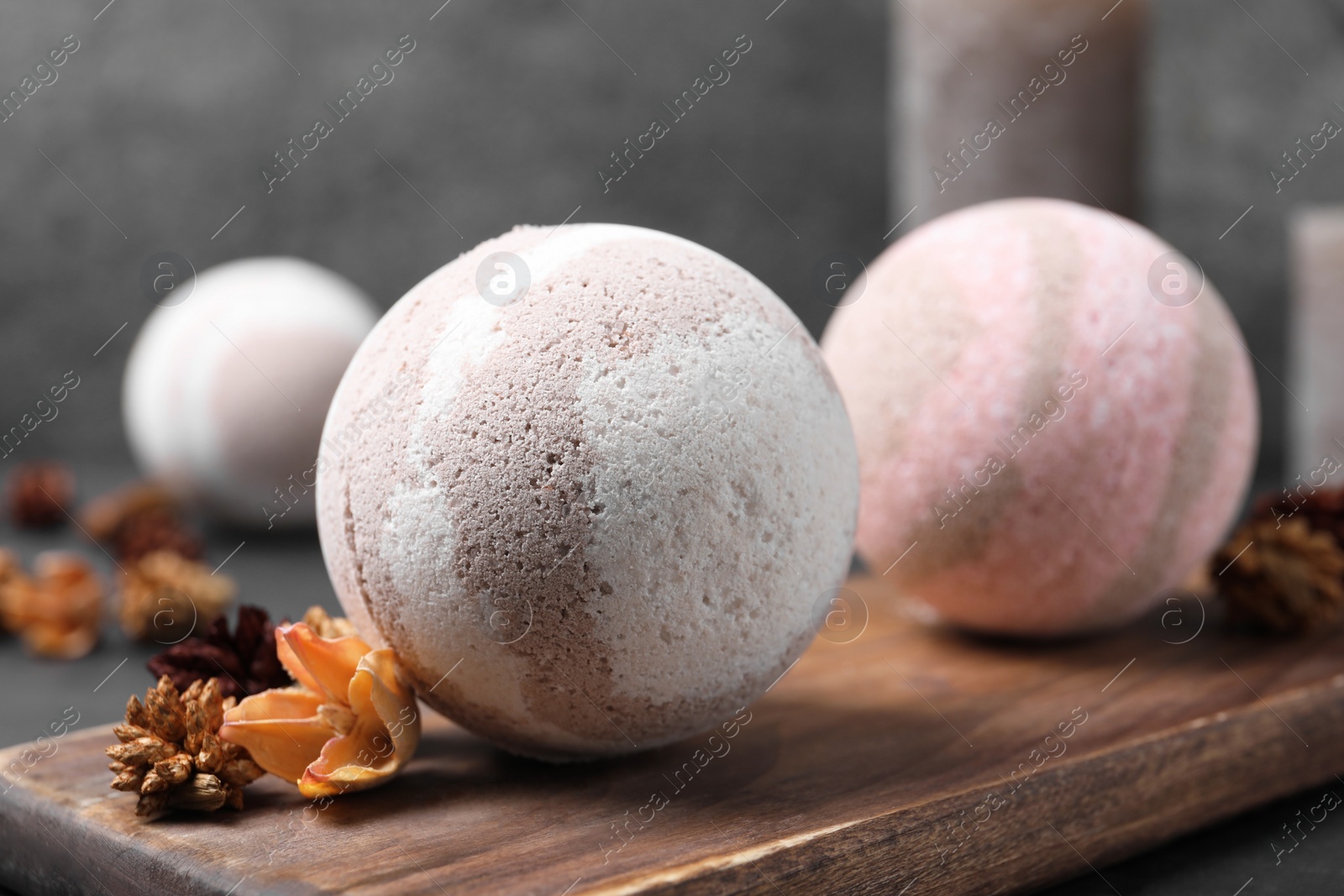 Photo of Bath bombs and dry flowers on table, closeup