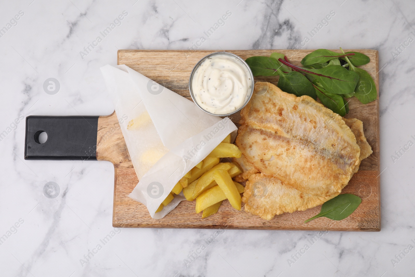 Photo of Delicious fish and chips with tasty sauce and mangold on white marble table, top view