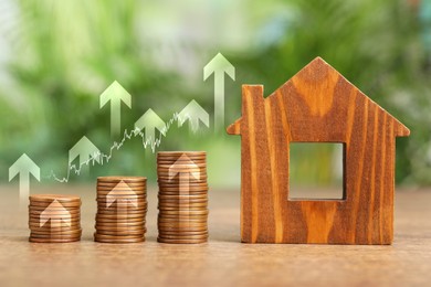 Image of Mortgage rate. Model of house, stacked coins, graph and upward arrows