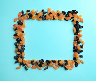 Photo of Frame made of raisins on color background, top view with space for text. Dried fruit as healthy snack