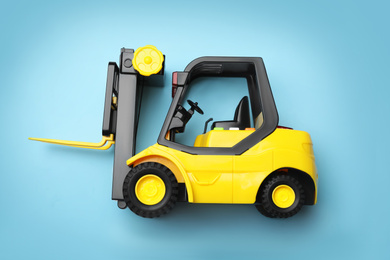 Photo of Top view of toy forklift on blue background. Logistics and wholesale concept
