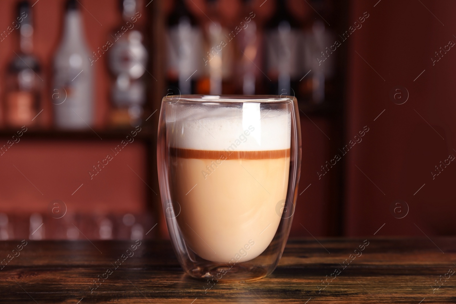 Photo of Glass with delicious latte on counter in bar