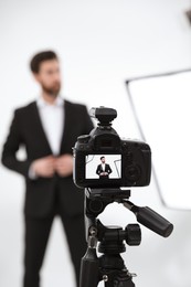 Photo of Handsome model posing for camera in modern studio, selective focus. Professional photo session