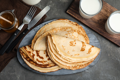 Flat lay composition with fresh thin pancakes on grey table