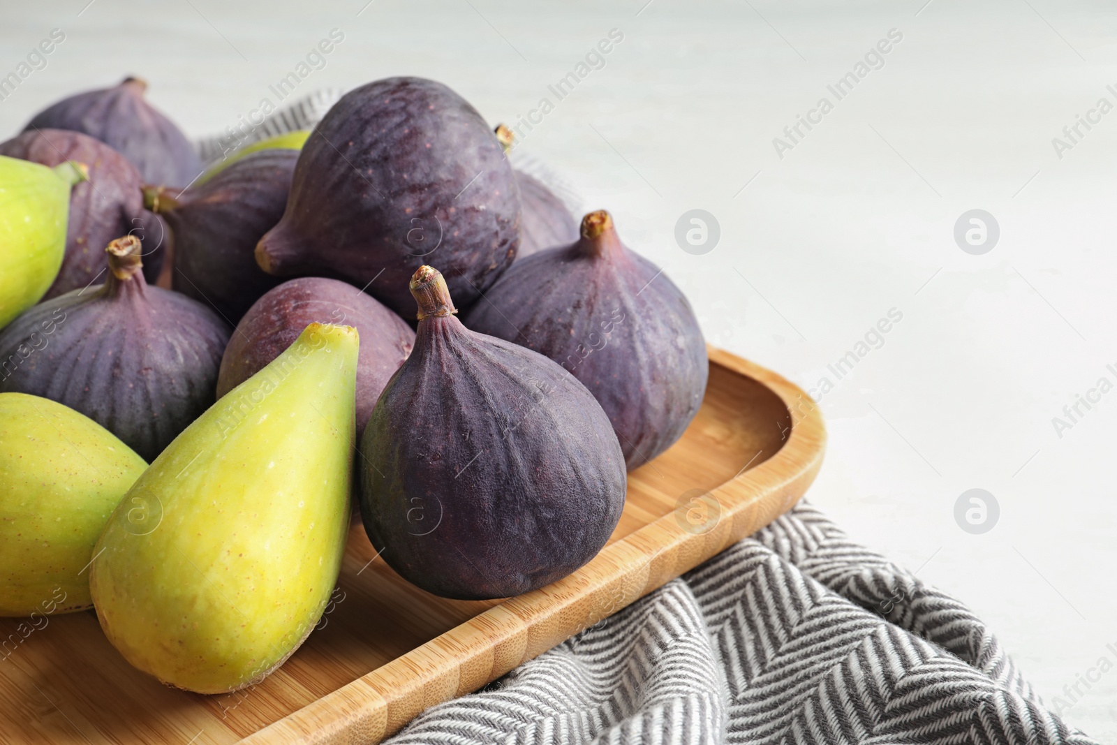 Photo of Plate with assorted ripe figs on table. Tropical fruit