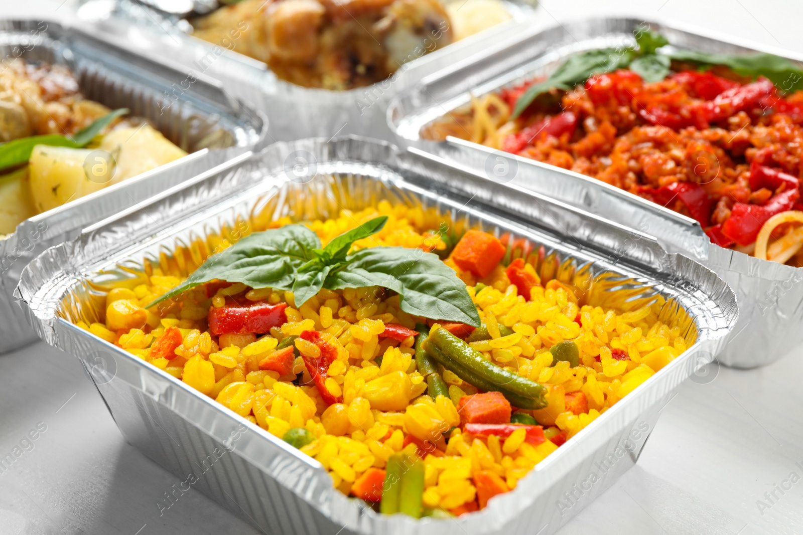 Photo of Lunchboxes on white wooden table, closeup. Healthy food delivery