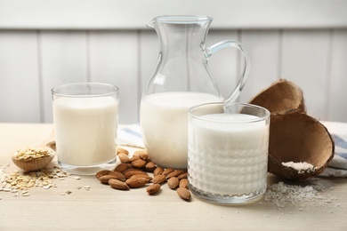 Photo of Composition with different types of milk on wooden table