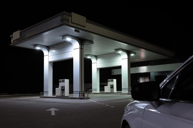 Photo of Modern car driving to gas station at night, closeup