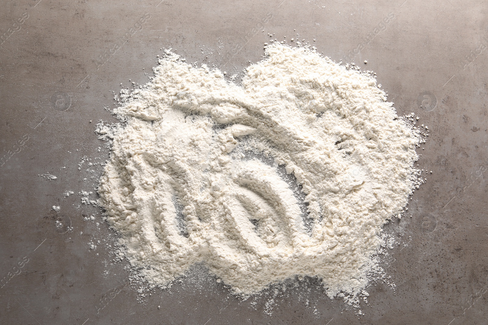 Photo of Pile of flour on grey textured table, top view