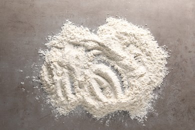 Photo of Pile of flour on grey textured table, top view