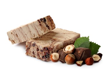 Image of Tasty halva, pieces of chocolate, hazelnuts and green leaves isolated on white