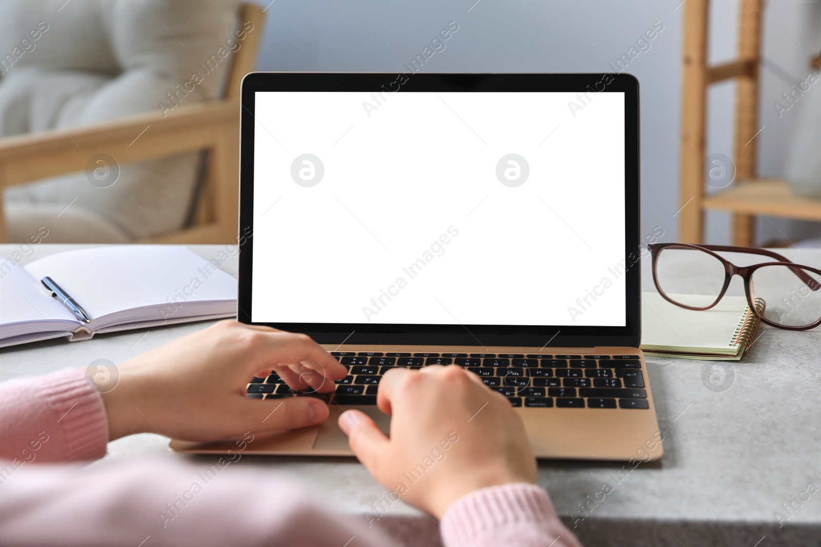 Photo of Woman working on laptop at white table, closeup. Mockup for design